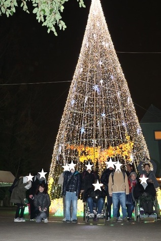 大きなクリスマスツリーのイルミネーションの前で写した集合写真