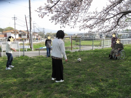 参加者たちが輪になってサッカーボールを蹴っている。